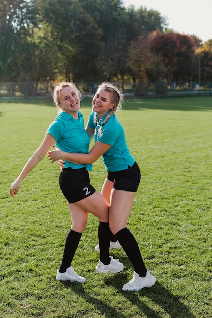 Foto grátis jogadores de futebol feminino, abraçando uns aos outros