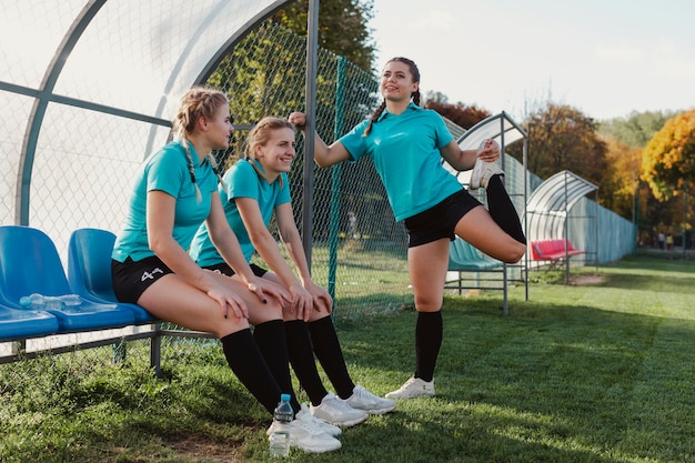 Jogadores de futebol feminino, sentado num banco