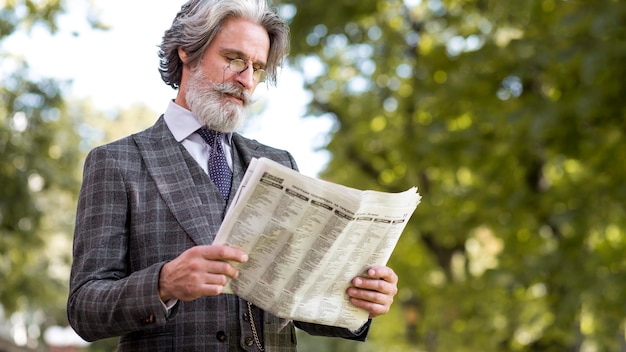 Foto grátis jornal de leitura masculino maduro elegante