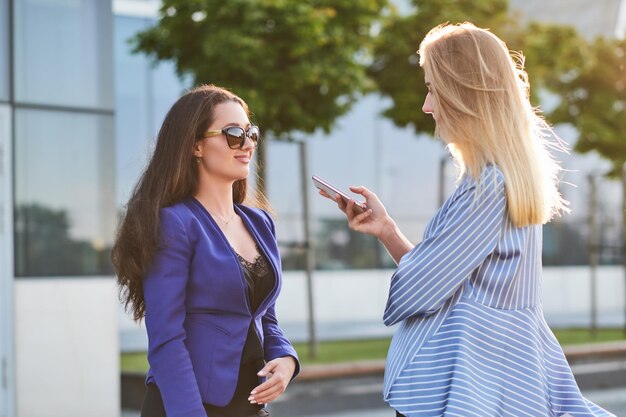 Jornalista curioso está recebendo entrevista de empresária de sucesso na rua.