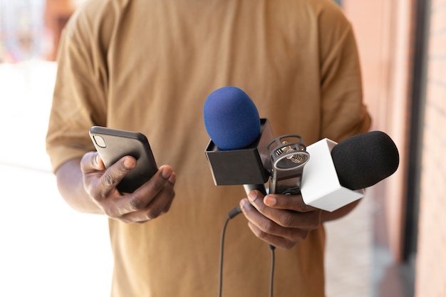 Foto grátis jornalista de visão frontal segurando um microfone