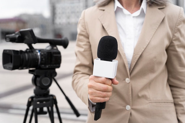 Foto grátis jornalista de visão frontal segurando um microfone