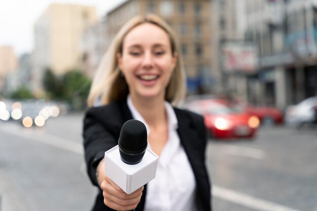 Jornalista de visão frontal segurando um microfone