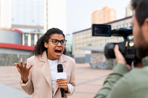 Foto grátis jornalista feminina contando as notícias do lado de fora