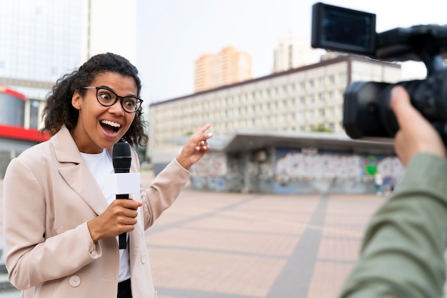 Jornalista feminina contando as notícias do lado de fora