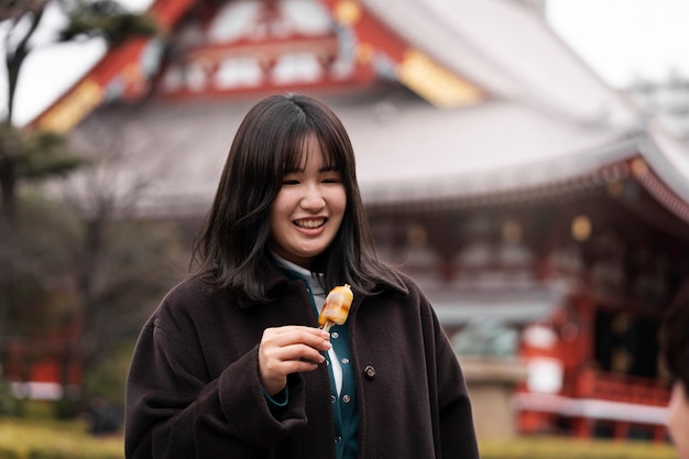 Jovem adulto desfrutando de comida de rua japonesa