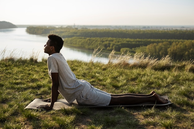 Foto grátis jovem adulto desfrutando de ioga na natureza