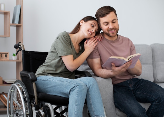 Jovem adulto lendo com amigo com deficiência