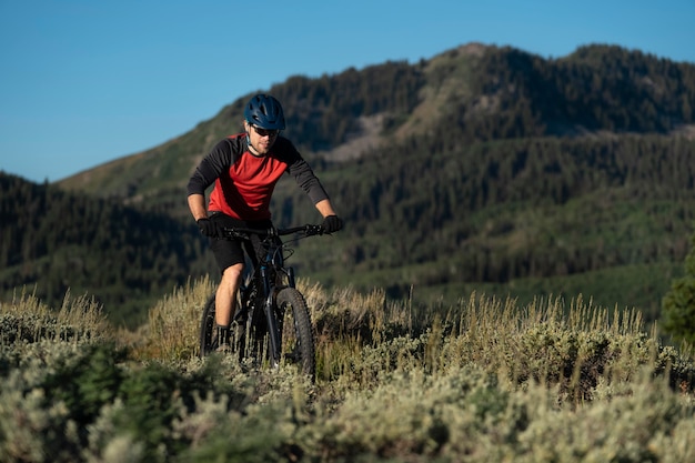 Foto grátis jovem adulto usando bicicleta elétrica no interior