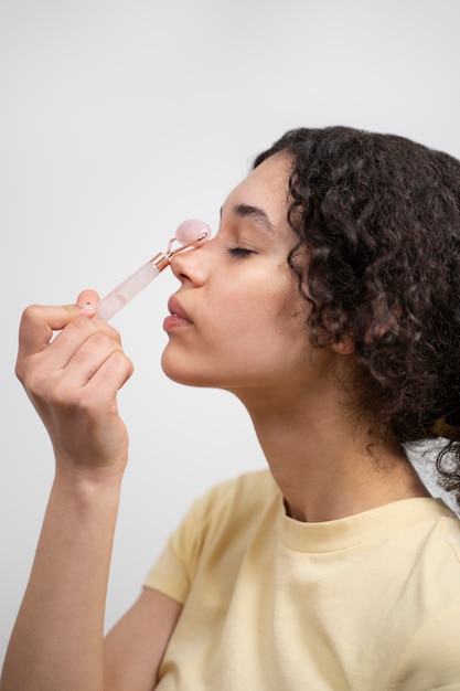 Foto grátis jovem adulto usando produto para cuidados com o rosto