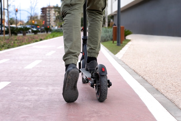 Jovem adulto usando scooter elétrico para transporte