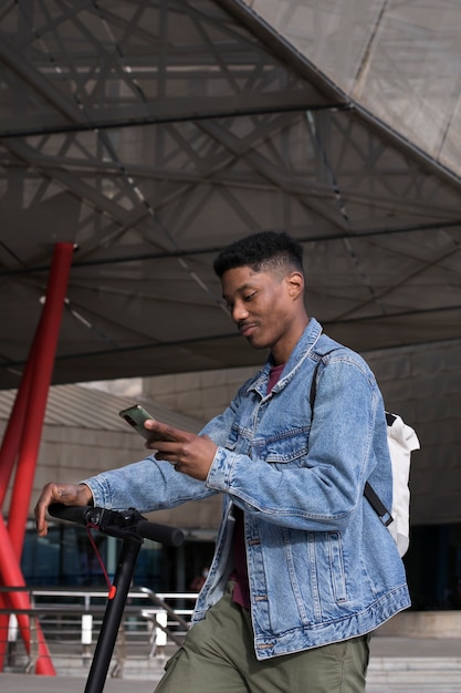 Foto grátis jovem adulto usando scooter elétrico para transporte