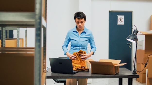 Foto grátis jovem adulto usando suprimentos de armazenamento para colocar em embalagens cartonadas, planejando entrega e remessa. funcionário colocando mercadorias e produtos para enviar aos clientes, desenvolvimento de negócios.