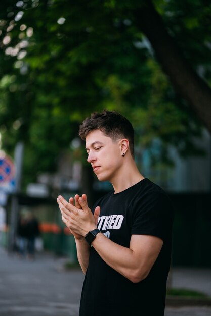 Jovem adulto vestindo uma camiseta preta e jeans caminhando em uma rua