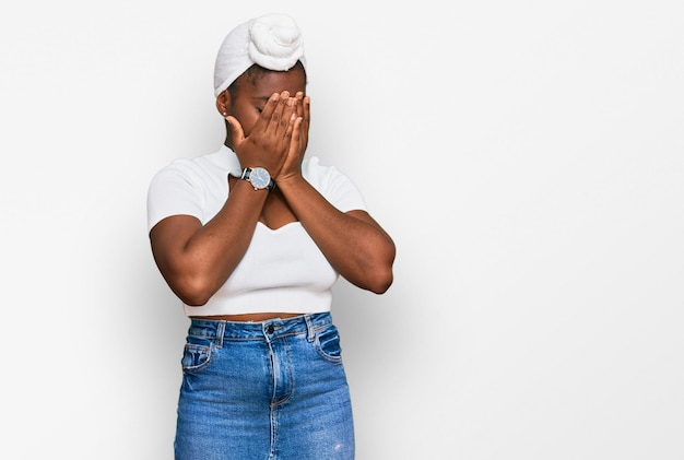 Foto grátis jovem africana com turbante usando turbante de cabelo sobre fundo isolado com expressão triste, cobrindo o rosto com as mãos enquanto chorava. conceito de depressão.