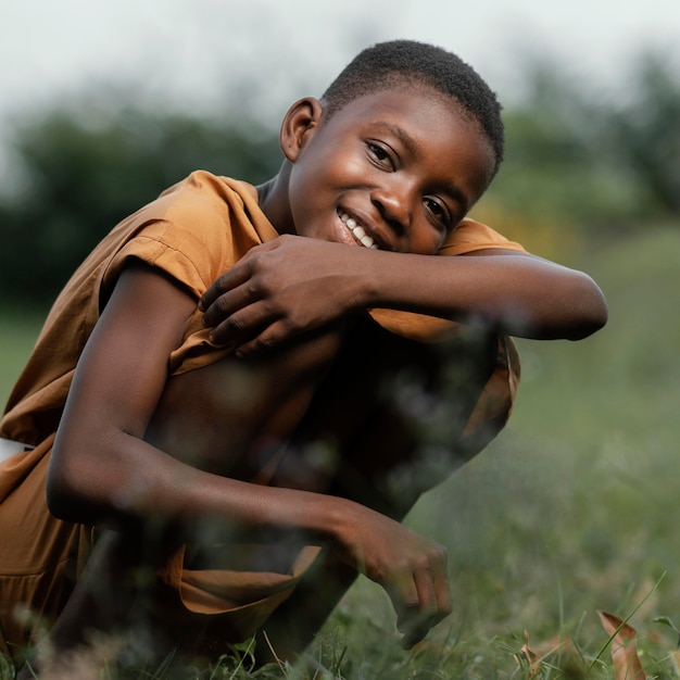 Jovem africano sorridente em pé no campo