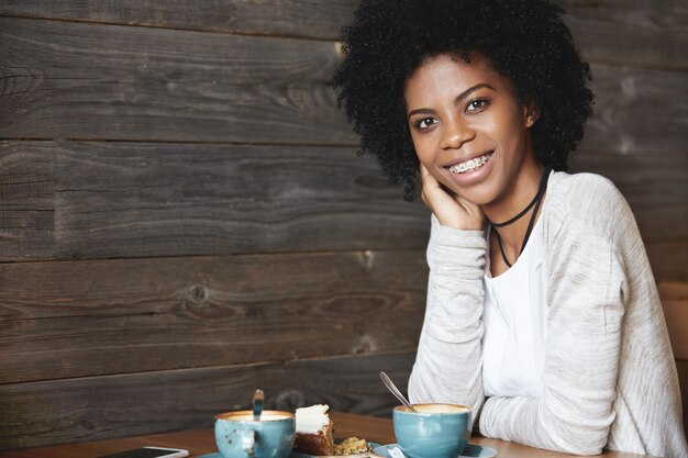 Jovem afro-americana sentada em um café