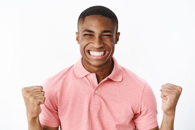 Foto grátis jovem afro-americano bonito com camiseta polo rosa