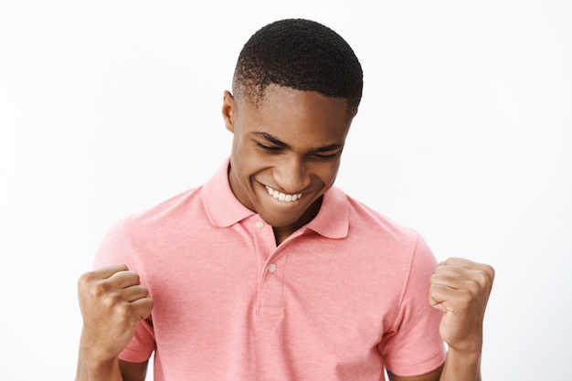 Jovem afro-americano bonito com camiseta polo rosa