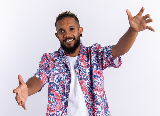 Jovem afro-americano com uma camisa colorida, olhando para a câmera, feliz e alegre