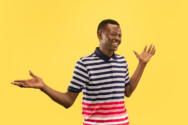 Jovem afro-americano isolado no fundo amarelo do estúdio, conceito de emoções humanas.