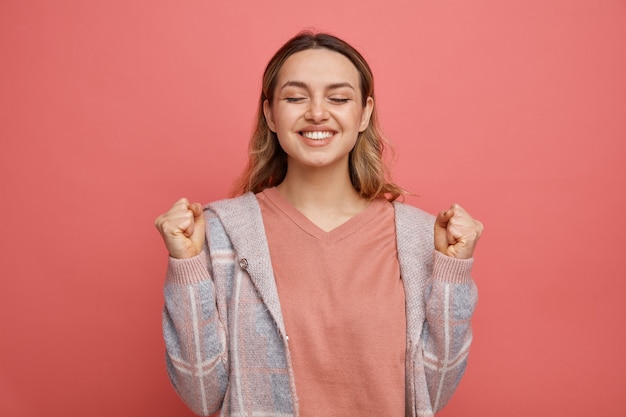 Jovem alegre fazendo gesto de sim com os olhos fechados