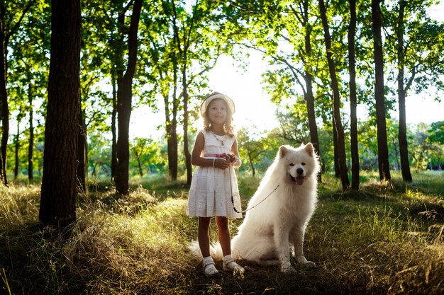 Jovem andando, brincando com o cachorro no parque ao pôr do sol.