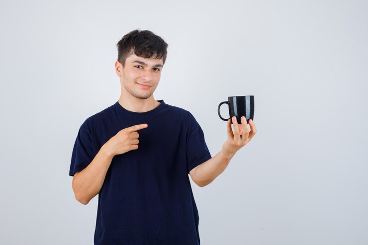 Foto grátis jovem, apontando para o copo de camiseta preta e parecendo confiante, vista frontal.