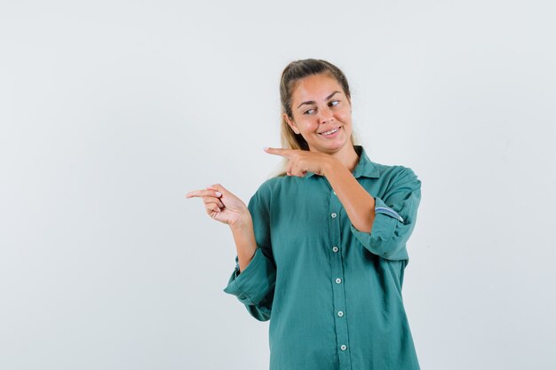 Jovem apontando para o lado com uma camisa azul e parecendo segura