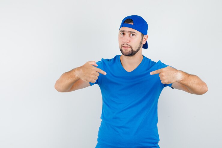 Foto grátis jovem apontando para si mesmo de camiseta azul e boné e parecendo confiante