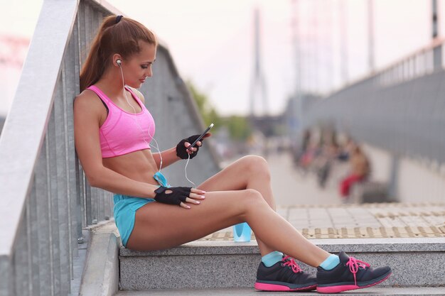 Jovem apta a mulher em roupas esportivas ao ar livre