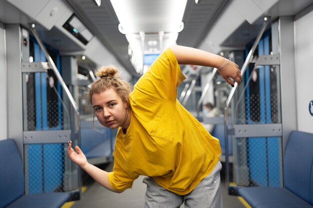 Jovem artista feminina dançando em um trem do metrô