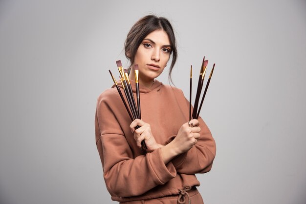 Jovem artista mostrando seus pincéis pretos