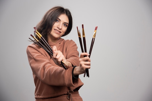 Jovem artista mostrando seus pincéis pretos