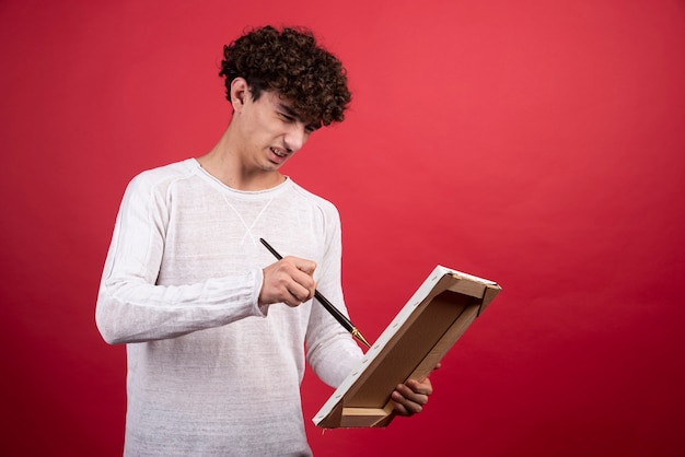 Jovem artista pintando algo na tela.