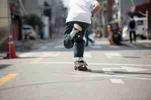 Foto grátis jovem asiático andando de skate na cidade ao ar livre