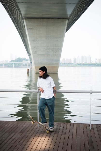 Jovem asiático andando de skate na cidade ao ar livre