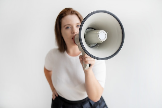 Jovem ativista feminina falando sobre suas idéias no megafone