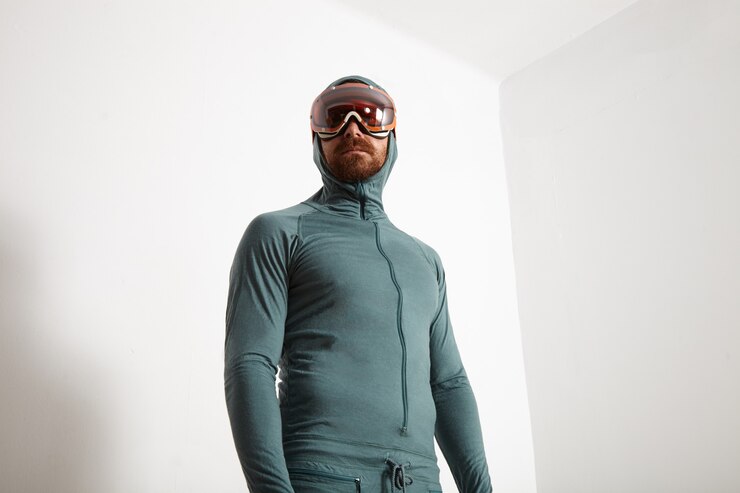 Foto grátis jovem atleta barbudo em forma de suíte térmica com camada de base e óculos de snowboard