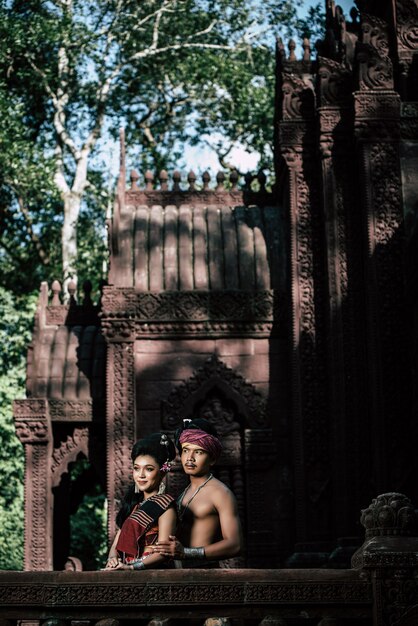 Jovem ator e atriz vestindo lindos trajes antigos, em monumentos antigos, estilo dramático. Interprete uma história popular de amor, lenda, um conto popular tailandês chamado "Phadaeng e Nang-ai" em um local antigo