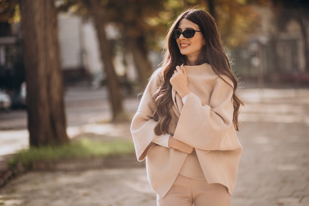 Foto grátis jovem atraente mulher de negócios andando na rua