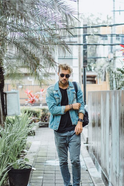 jovem atraente posando em um local tropical, em um fundo de palmeiras e vegetação