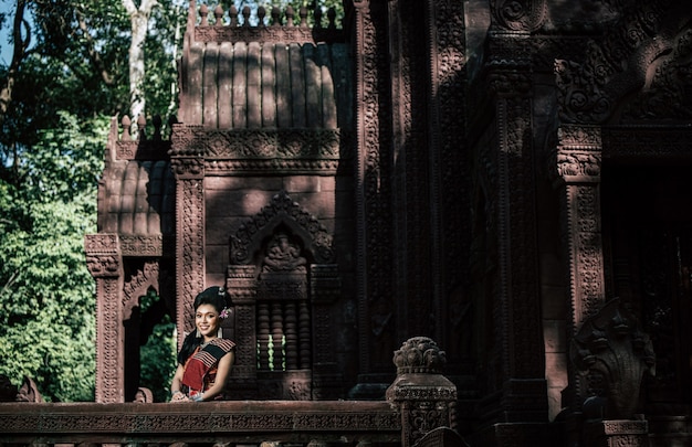 Jovem atriz vestindo lindos trajes antigos, em monumentos antigos, estilo dramático. Interprete uma história popular de amor, lenda, um conto popular tailandês chamado "Phadaeng e Nang-ai" em um local antigo