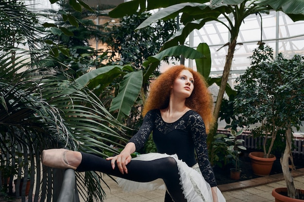 Foto grátis jovem bailarina dançando em um jardim botânico dentro de casa