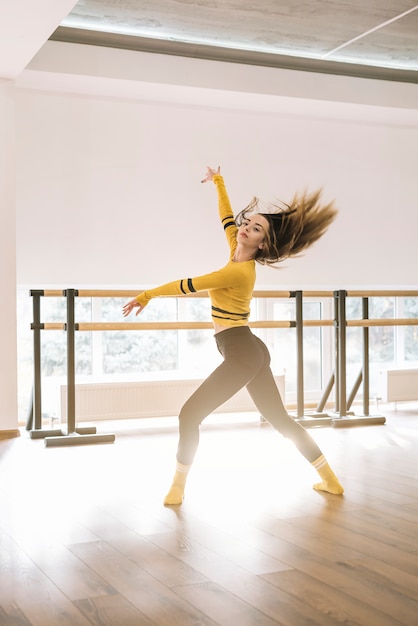 Foto grátis jovem bailarina feminina praticando no estúdio de dança