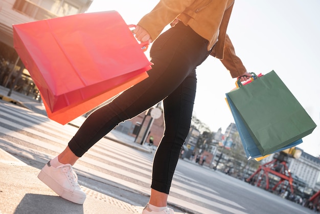 Jovem balançando sacos de compras na rua