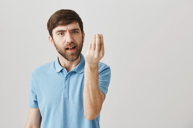 Jovem barbudo aborrecido e aborrecido posando