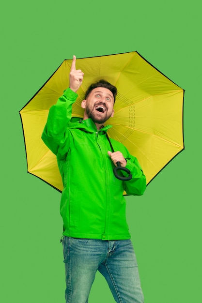 Foto grátis jovem barbudo bonito segurando guarda-chuva