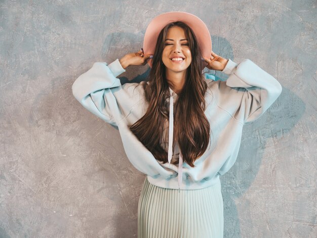 Jovem bela mulher sorridente olhando. Menina na moda em roupas de verão casual capuz e saia.