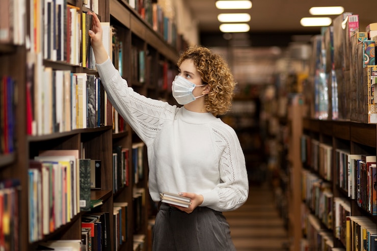 Foto grátis jovem bibliotecário a organizar livros